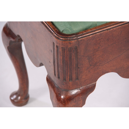 1114 - A GEORGE I WALNUT STOOL with shaped side rails, fluted corners and drop-in seat; standing on cabriol... 