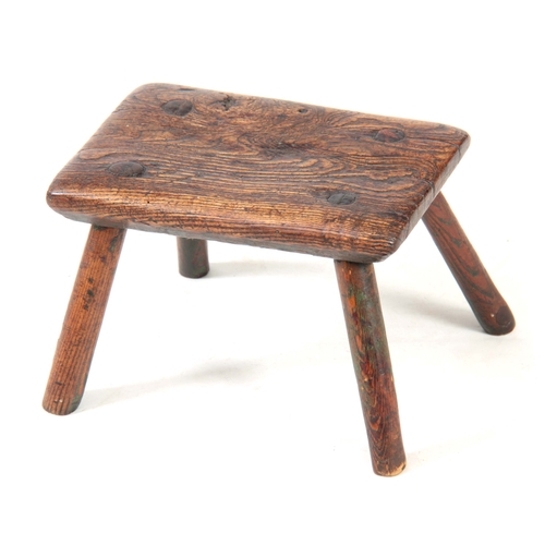 1122 - AN 18TH CENTURY OAK MILKING STOOL with thick-cut chamfered top, having traces of original green pain... 