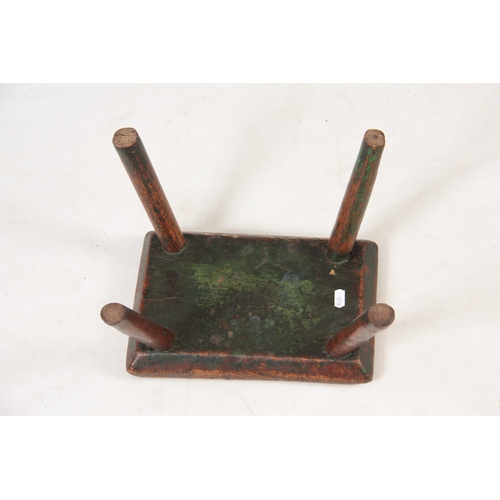 1122 - AN 18TH CENTURY OAK MILKING STOOL with thick-cut chamfered top, having traces of original green pain... 