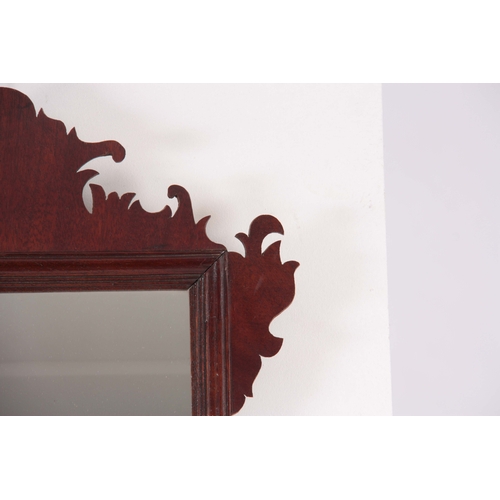 1124 - A 20TH CENTURY MAHOGANY FRET-CUT HANGING MIRROR having a rectangular mirror plate surrounded by a mo... 