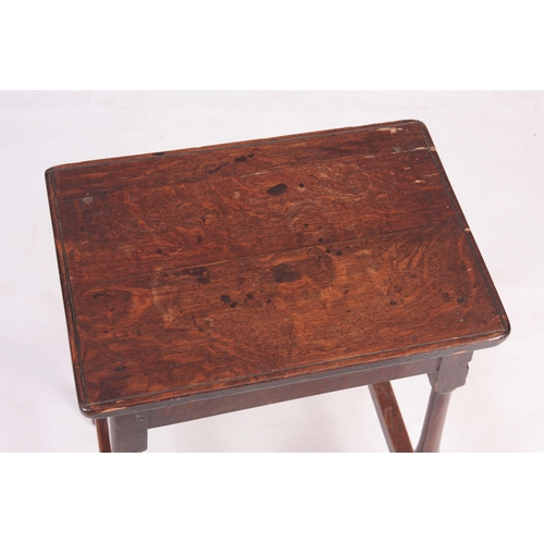 1134 - A 18TH CENTURY JOINED OAK STOOL with nailed top on a slender splayed baluster turned base with raise... 