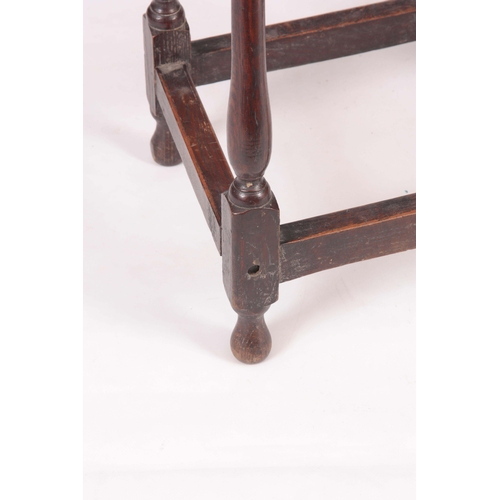 1134 - A 18TH CENTURY JOINED OAK STOOL with nailed top on a slender splayed baluster turned base with raise... 