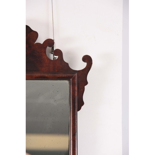 1137 - A 20TH CENTURY MAHOGANY FRET-CUT HANGING MIRROR having a rectangular mirror plate surrounded by a D ... 