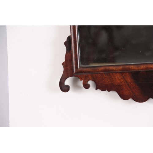 1137 - A 20TH CENTURY MAHOGANY FRET-CUT HANGING MIRROR having a rectangular mirror plate surrounded by a D ... 