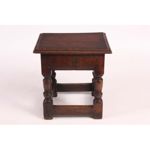 1140 - A 17th Century style joined Oak STOOL the dowelled moulded edge seat on ringed turned legs and raise... 