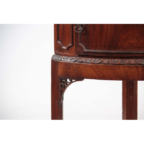 1141 - A GEORGE III MAHOGANY CORNER BEDSIDE TABLE with hinged door above a carved moulded edge, standing on... 