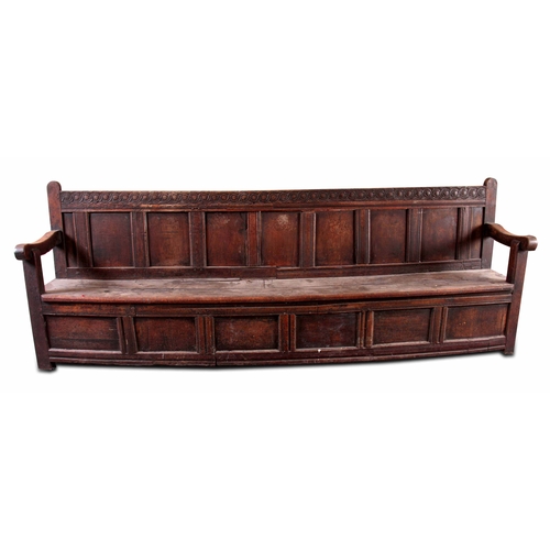 1159 - A RARE OVERSIZED 17TH CENTURY AND LATER JOINED OAK BOX SETTLE with an arcaded carved top rail, panel... 