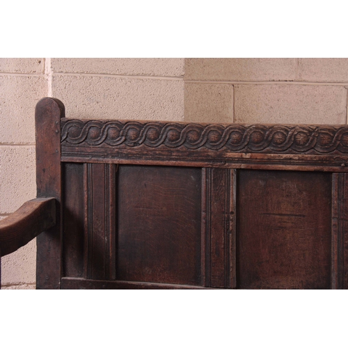 1159 - A RARE OVERSIZED 17TH CENTURY AND LATER JOINED OAK BOX SETTLE with an arcaded carved top rail, panel... 