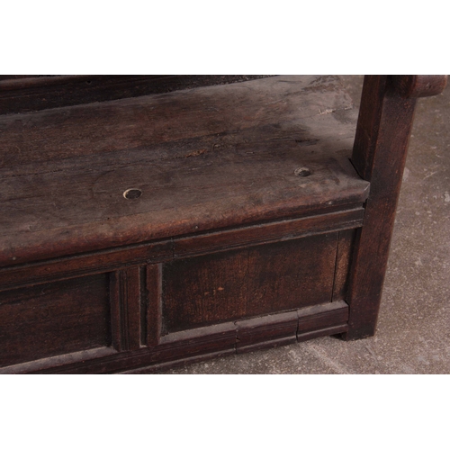 1159 - A RARE OVERSIZED 17TH CENTURY AND LATER JOINED OAK BOX SETTLE with an arcaded carved top rail, panel... 