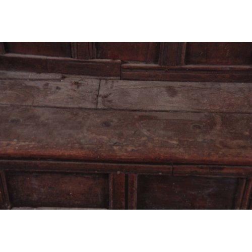 1159 - A RARE OVERSIZED 17TH CENTURY AND LATER JOINED OAK BOX SETTLE with an arcaded carved top rail, panel... 