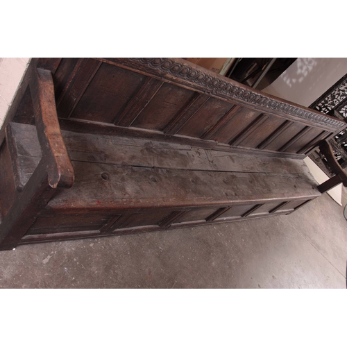 1159 - A RARE OVERSIZED 17TH CENTURY AND LATER JOINED OAK BOX SETTLE with an arcaded carved top rail, panel... 