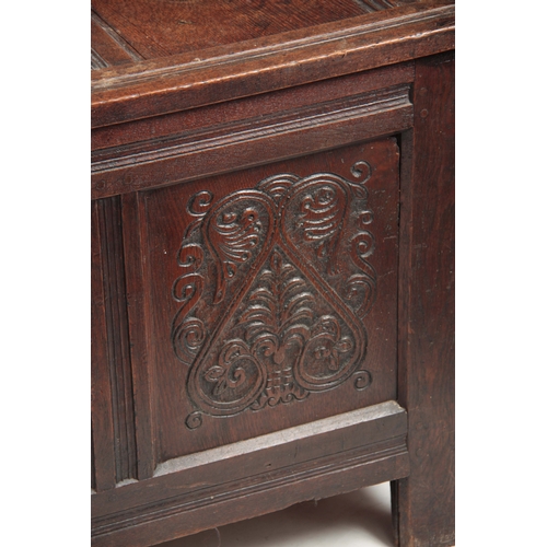 1160 - A 17TH CENTURY JOINED OAK FOUR PLANK WESTMORELAND COFFER with hinged lid above four carved scrolled ... 