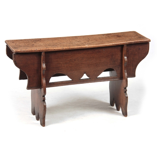 1162 - A LATE 17th CENTURY OAK BENCH  with single plank top above a deep shaped frieze standing on two tres... 