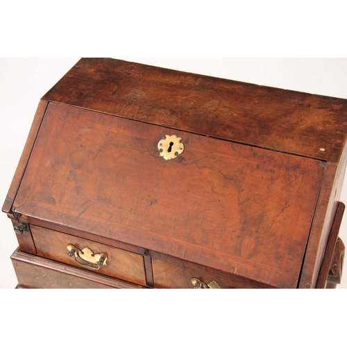 1172 - A GEORGE I STYLE WALNUT BUREAU ON STAND with angled fall revealing an interior of pigeon holes and s... 