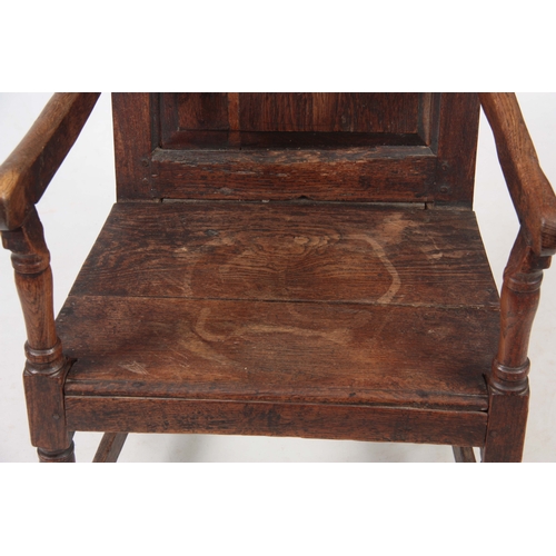 1180 - AN EARLY 18TH CENTURY OAK WAINSCOT CHAIR having fielded panel back with open arms and turned support... 