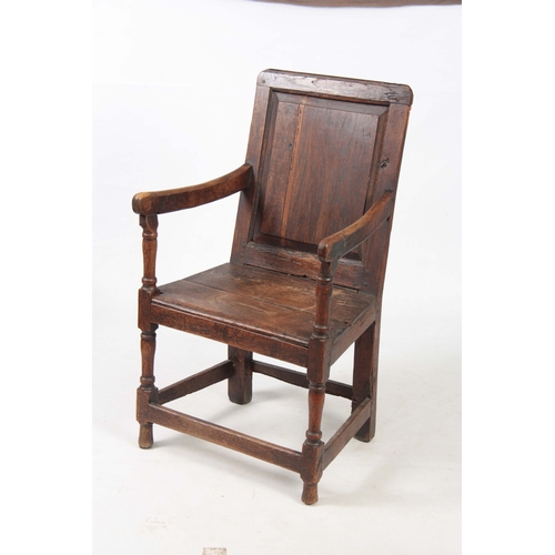 1180 - AN EARLY 18TH CENTURY OAK WAINSCOT CHAIR having fielded panel back with open arms and turned support... 