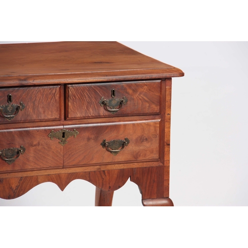 1198 - AN 18TH CENTURY FIGURED WALNUT LOWBOY with three drawers fitted with shaped brass handles; standing ... 