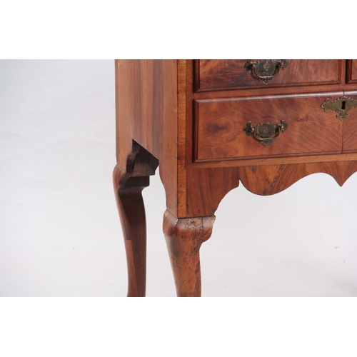 1198 - AN 18TH CENTURY FIGURED WALNUT LOWBOY with three drawers fitted with shaped brass handles; standing ... 