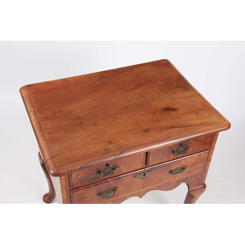 1198 - AN 18TH CENTURY FIGURED WALNUT LOWBOY with three drawers fitted with shaped brass handles; standing ... 