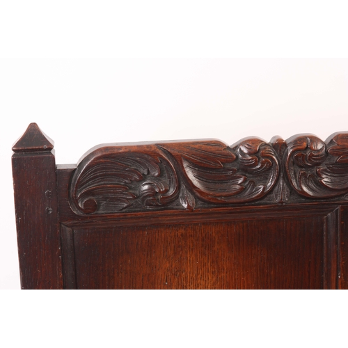 1221 - A CHARLES II JOINED OAK SETTLE with quadruple panelled back and bold leaf and shell carved top rail,... 