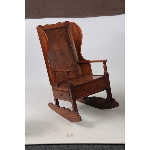 1236 - AN 18th CENTURY ELM LAMBING CHAIR with shaped back and headrest above open arms with panelled seat a... 