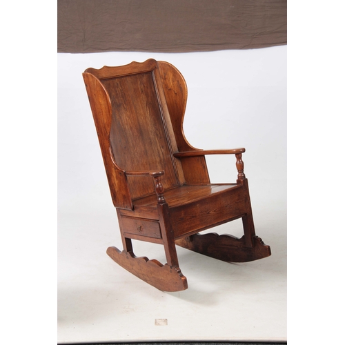 1236 - AN 18th CENTURY ELM LAMBING CHAIR with shaped back and headrest above open arms with panelled seat a... 