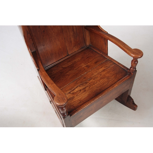 1236 - AN 18th CENTURY ELM LAMBING CHAIR with shaped back and headrest above open arms with panelled seat a... 