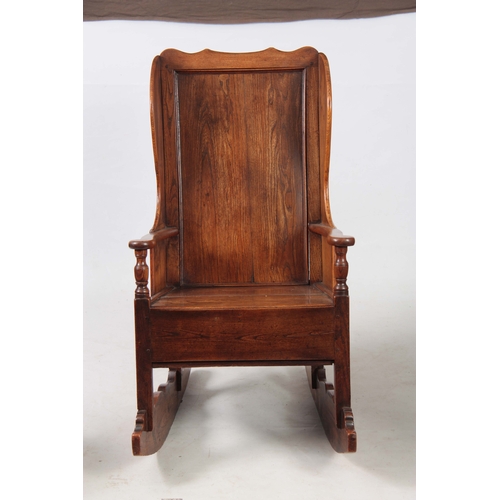 1236 - AN 18th CENTURY ELM LAMBING CHAIR with shaped back and headrest above open arms with panelled seat a... 