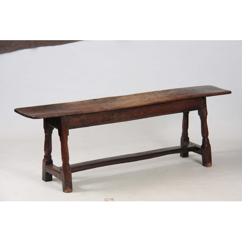 1241 - A RARE 17TH CENTURY JOINED OAK BENCH with single plank top above angled ringed turned legs united by... 