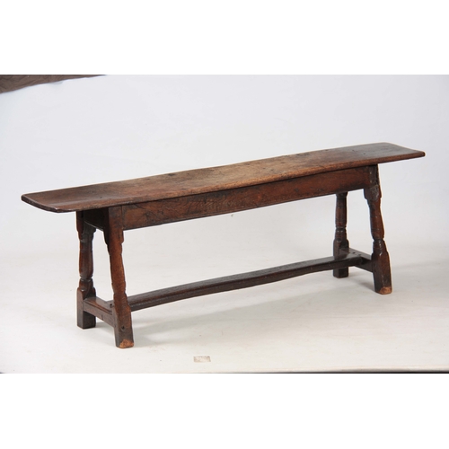 1241 - A RARE 17TH CENTURY JOINED OAK BENCH with single plank top above angled ringed turned legs united by... 