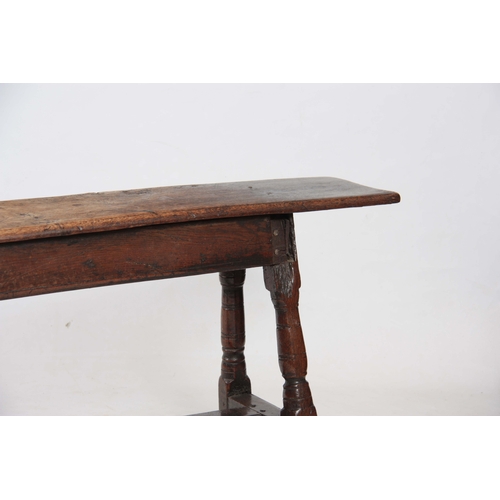 1241 - A RARE 17TH CENTURY JOINED OAK BENCH with single plank top above angled ringed turned legs united by... 