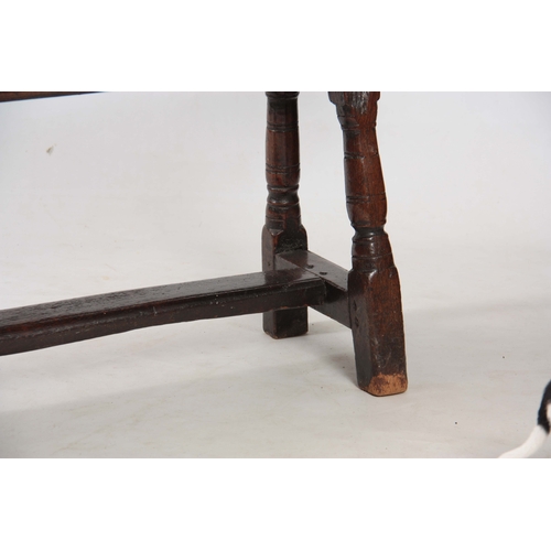 1241 - A RARE 17TH CENTURY JOINED OAK BENCH with single plank top above angled ringed turned legs united by... 