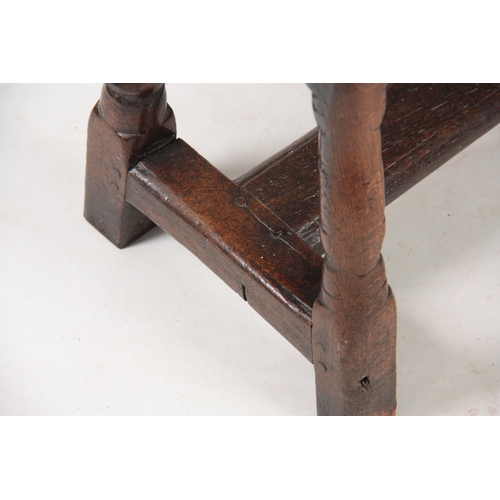 1241 - A RARE 17TH CENTURY JOINED OAK BENCH with single plank top above angled ringed turned legs united by... 