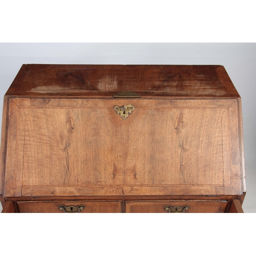 1283 - A SMALL EARLY 18TH CENTURY WALNUT BUREAU having an angled hinged fall revealing an interior of small... 