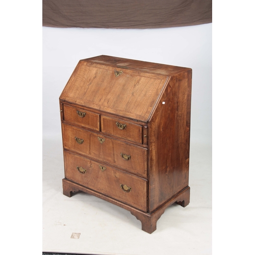 1283 - A SMALL EARLY 18TH CENTURY WALNUT BUREAU having an angled hinged fall revealing an interior of small... 