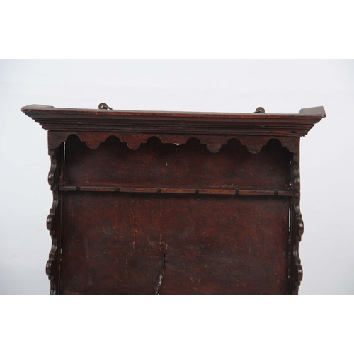 1288 - AN 18TH CENTURY OAK AND FRUITWOOD HANGING SPOON RACK with moulded cornice above wavey edge shaped si... 