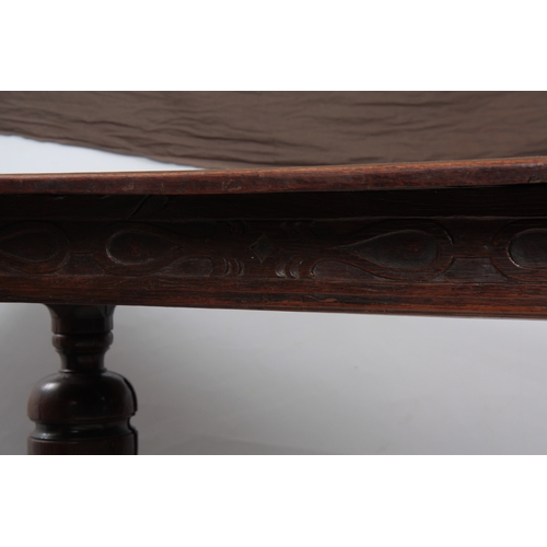 1295 - AN EARLY 18TH CENTURY OAK REFECTORY TABLE with plank top above a carved blind fret frieze; standing ... 