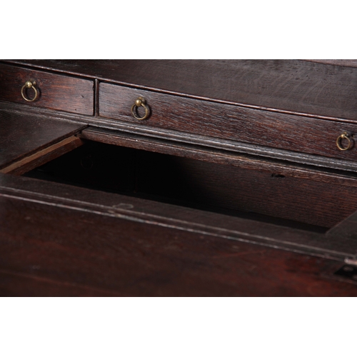 1297 - AN 18TH CENTURY OAK BUREAU ON STAND with hinged angled fall fitted with three iron locks having bras... 