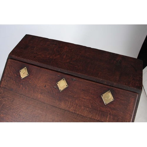 1297 - AN 18TH CENTURY OAK BUREAU ON STAND with hinged angled fall fitted with three iron locks having bras... 