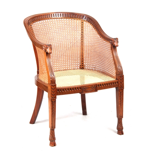 1303 - A LATE 19TH CENTURY ADAM STYLE BERGERE CHAIR with arcaded shaped back and rams head arms above leaf ... 