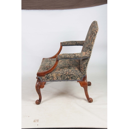 1309 - A LATE 19TH CENTURY WALNUT GEORGE I STYLE GAINSBOROUGH CHAIR with upholstered back and sweeping arms... 