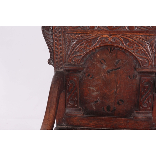 1317 - A 17TH CENTURY AND LATER OAK WAINSCOT CHAIR with eared shaped carved top rail centred  by an arched ... 