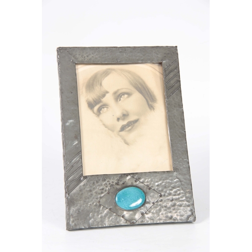 462 - AN ARTS AND CRAFTS BEATEN PEWTER PHOTOGRAPH FRAME set with a blue Ruskin style large oval ceramic me... 