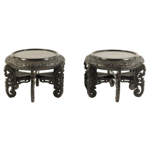 118 - A PAIR OF 19TH CENTURY CHINESE CARVED EBONISED HARDWOOD VASE STANDS the recessed circular tops with ... 