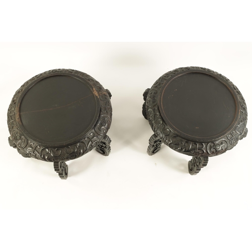 118 - A PAIR OF 19TH CENTURY CHINESE CARVED EBONISED HARDWOOD VASE STANDS the recessed circular tops with ... 