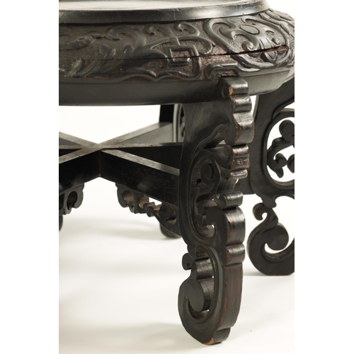 118 - A PAIR OF 19TH CENTURY CHINESE CARVED EBONISED HARDWOOD VASE STANDS the recessed circular tops with ... 