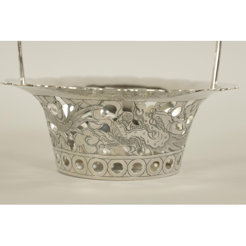 120 - A PAIR OF CHINESE SILVER SWEETMEAT BASKETS with double entwined loop handles on periced engraved bod... 