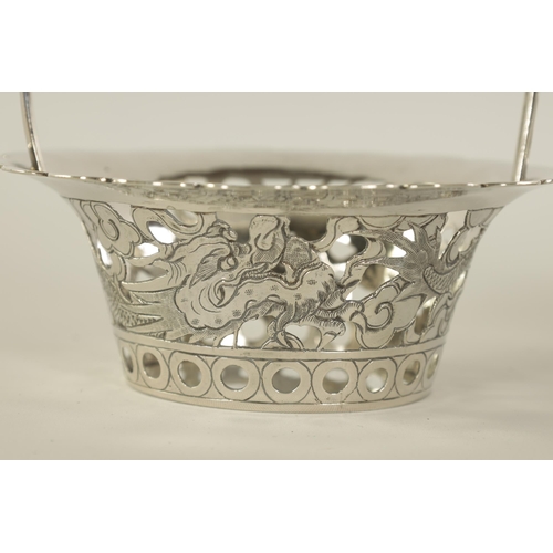 120 - A PAIR OF CHINESE SILVER SWEETMEAT BASKETS with double entwined loop handles on periced engraved bod... 