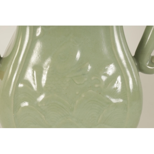 137 - A 19TH CENTURY CELADON GLAZED CHINESE VASE of shaped bulbous form with tusk side handles, panelled f... 