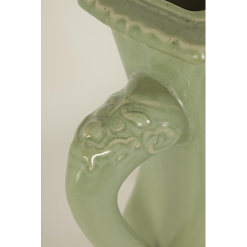 137 - A 19TH CENTURY CELADON GLAZED CHINESE VASE of shaped bulbous form with tusk side handles, panelled f... 